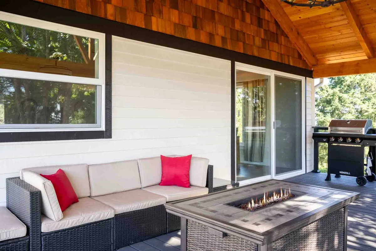 This image features an inviting outdoor seating area complete with a fire pit and grill, surrounded by comfortable chairs and nestled under the open sky. The scene is set for shared stories, laughter, and outdoor meals, suggesting a perfect atmosphere for group gatherings and evening relaxation.